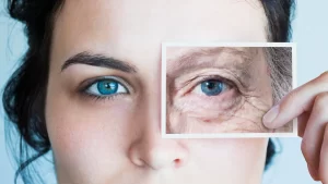 a young woman holding a picture up to one eye; the picture is the eye of an elderly person