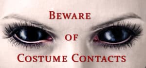 a picture of a woman with all black eyes and text reading "beware of costume contacts"